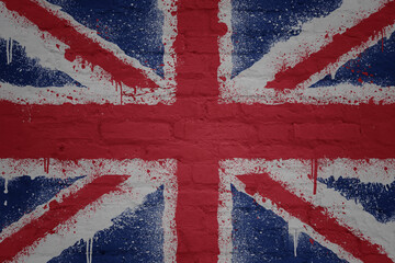 colorful painted big national flag of great britain on a massive brick wall