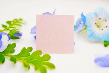 白背景に青く綺麗なネモフィラの花と葉をデコレーションしたピンクの可愛いタイトルカードのモックアップ