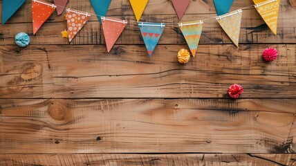 Colorful party decorations including bunting and pom-poms against a rustic wooden backdrop. - obrazy, fototapety, plakaty