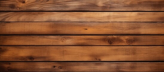 A closeup of a brown hardwood plank wall with amber tints and shades, showcasing a beautiful wood stain pattern. Blurred background adds depth
