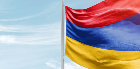 Armenia national flag with mast at light blue sky.