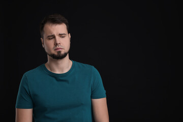Obraz premium Portrait of sad man on black background, space for text