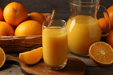 Tasty fresh oranges and juice on wooden table, closeup