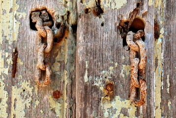 Una vieja puerta de madera marcada por el paso del tiempo y los elementos. - obrazy, fototapety, plakaty
