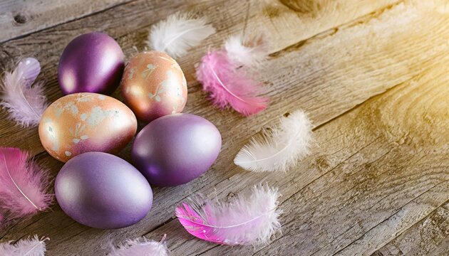 purple and pink easter eggs with feathers on a wooden background with space for a text or an image with space for your own text