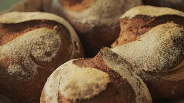 Fresh artesian bread on bakery shop close-up. Bread with black poppy garnish on top and white flour on top. Artisan bread is making by skill bakers using natural and