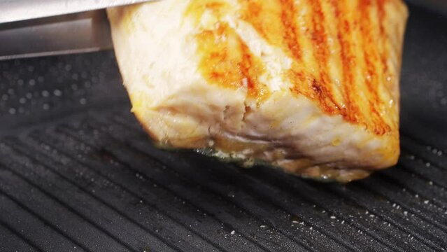 Cooking fillet sturgeon beluga white fat fish on grill or frying pan with oil close-up. Roast healthy food concept. Fry sturgeon, hake, cod fish steak pieces fillet. Healthy diet