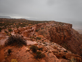 Red sandstone cliffs on desert mesa wet from rain during storm in St. George Utah