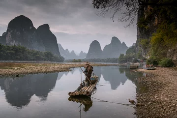 Papier Peint photo autocollant Guilin Cormorant fisherman and his bird on the Li River in Yangshuo, Guangxi, China.