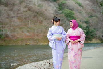 Travel, muslim travel, Arashiyama, woman girl tourist Two Asian friends but different religions in traditional japanese kimonos walking and travel   to Tenryu-ji temple, Kyoto, Arashiyama, Japan.