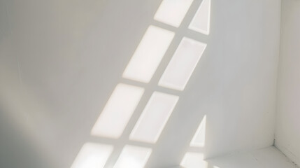 Natural light rays casting minimal shadows on white wall.