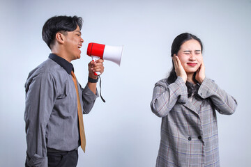 Asian businessman shouting at his partner using a megaphones