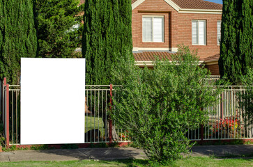 Real Estate Billboard Mockup Outside a Suburban Australian House: An empty, blank white background provides texture for advertising. ample copy space for your 'House for Sale' or 'For Rent' designs.