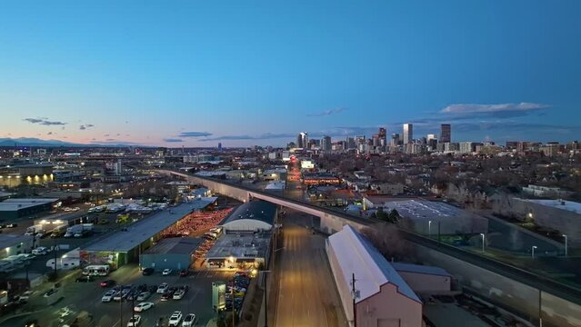 Blue hour glow with yellow building lights illuminate street, Denver Colorado downtown off in distance at dusk