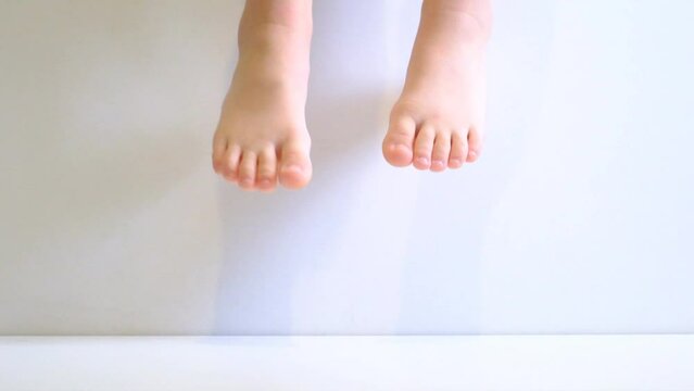 Barefoot child, teenager on white floor moving up, flying, levitation. Sleepwalker