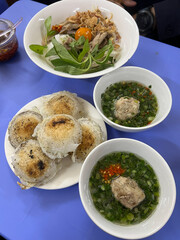 Banh can or fried mini pan cake. Vietnamese cuisine, Dalat style. Powder is steamed with pork or prawn in small round clay shape pan. It's not deep fried, Eat with herbs and fermented fish sauce.