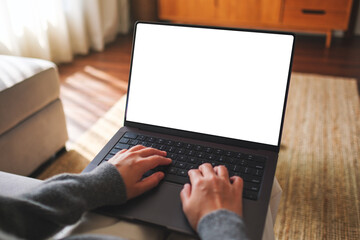 Mockup image of a woman working and typing on laptop computer with blank white desktop screen at home - 769319179