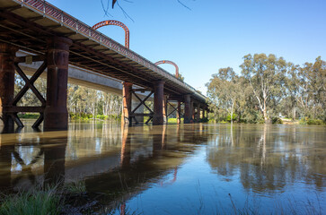 The historic Echuca-moama Road Rail Bridge over the calm waters of the Murray River. It's between...