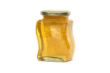 Glass jar filled with honey and honeycomb isolated on white
