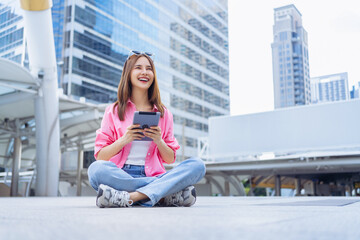 Young Asian woman sit and relax and use tablet with camera and looking for tourist attractions.