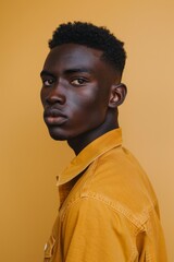 Obraz premium Confident young man with a serious expression against a yellow background