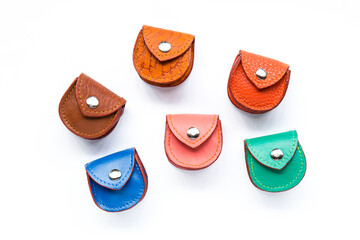 Closeup of coins and leather pocket purse. Isolated on white background