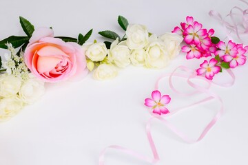 Obraz na płótnie Canvas 白背景に薔薇の花とピンクのリボンの背景、バラの花のフレーム