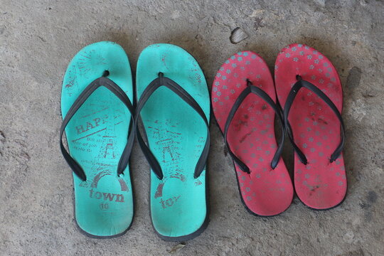 Two pairs of slippers on the cement floor. Two house slippers for men and women. Showing couple love concept and family concept.