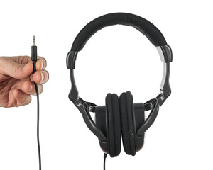 Photo of old black headphones and male hand holding jack, Musical artifacts: Aged headphones...