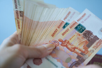 Hand holding a bundle of banknotes of five thousand rubles. 5000 rubles. - obrazy, fototapety, plakaty