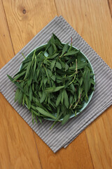 Bunch of fresh Bladder campion plants on a bowl on wooden table. Silene vulgaris plants harvest