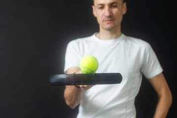 Paddle tennis player ready for serve on gray background