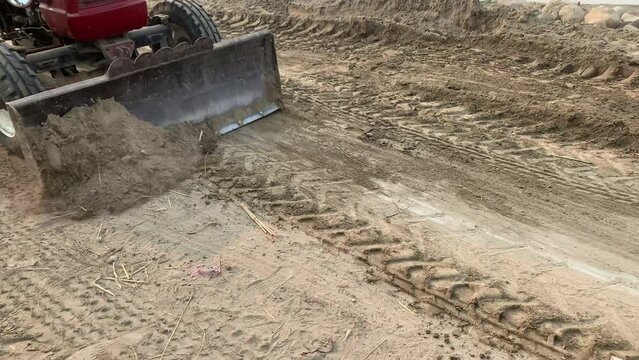Labor Day concept: close-up operation of the tractor footage slow motion. Road construction machinery, a tractor, moving the ground and preparing it for road construction. High quality 4k footage.
