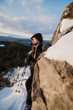 Young woman hikes Borestone Mountain, Maine in winter.