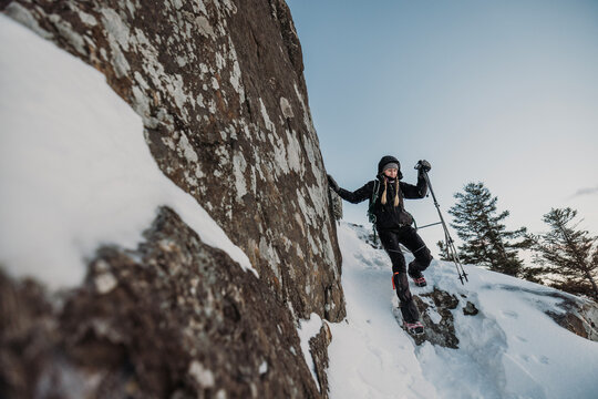Woman hiker descends steep trail in snow, Borestone Mountain, Maine