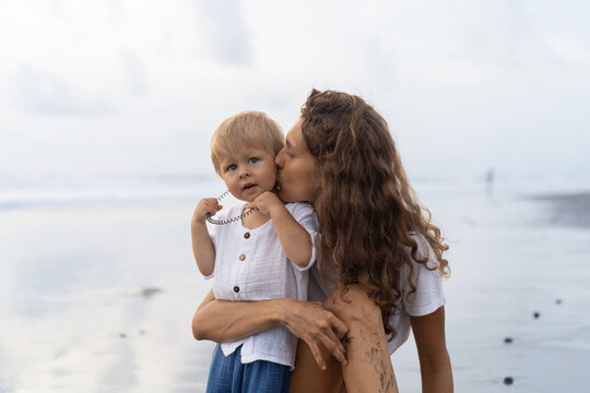 Mom with a small child son on the ocean shore. Bali