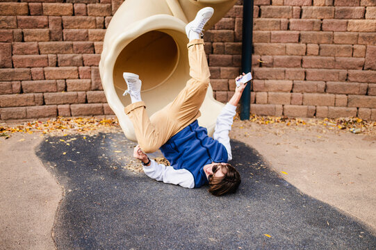 Teenager playfully falling from slide