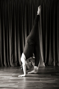 Woman in Standing Split in front of Curtain