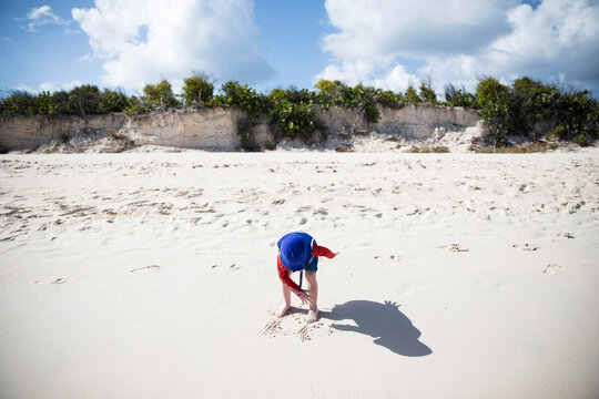 Wide Angle of Toddler Boy in Blue Bucket Hat and Shadow on Beach