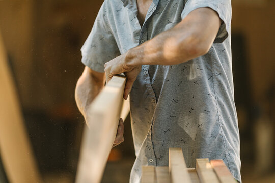 shaping timber in workshop, focused craftsmanship.
