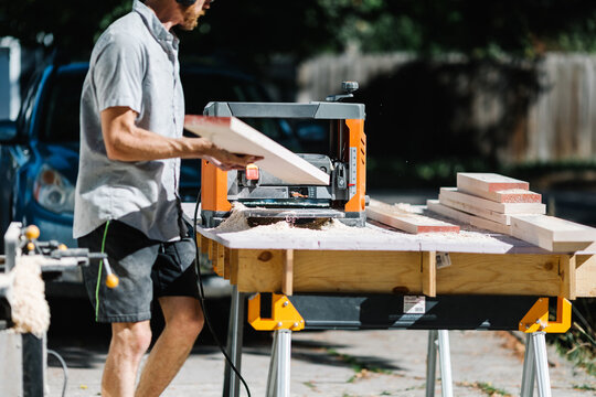 Carpenter using table saw on sunny day