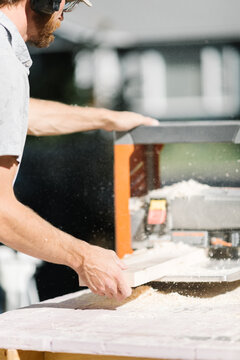 Carpenter precisely shaping wood with planer.