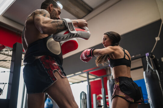 Female fighter sparring with personal coach during training session
