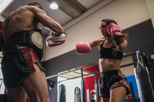 Female fighter sparring with personal coach during training session