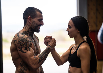 Happy couple holding hands while standing in gym