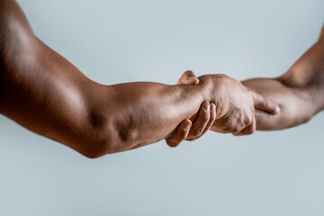 Rescue, helping gesture or hands. Strong hold. Close-up. Two hands, helping hand of a friend. Handshake, arms, friendship. Friendly handshake, friends greeting, teamwork - obrazy, fototapety, plakaty