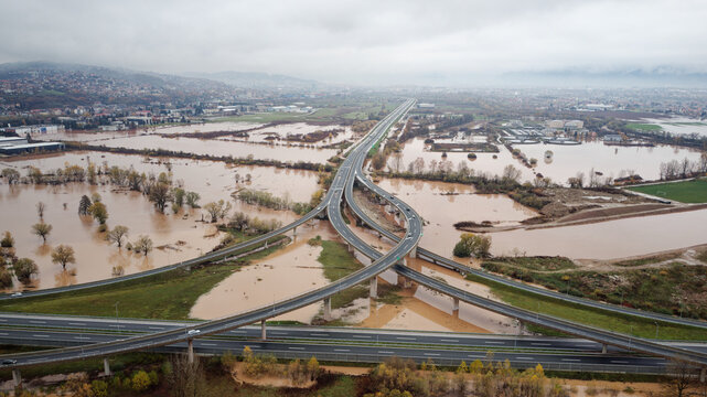 Aerial drone view of torrential rain causes flash floods in residential areas. Houses and roads surrounded by water. Climate change. Heavy rainfall consequences.