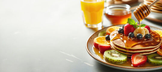 A plate of pancakes with fruit on top and glass of orange juice - obrazy, fototapety, plakaty