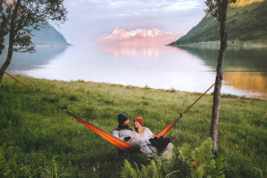 Happy couple chilling in hammock camping outdoor man and woman traveling together family lifestyle summer vacations, cheerful wife and husband romantic holidays in Norway, love candid emotions