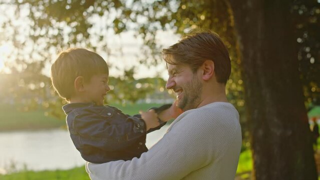 Dad and Son Enjoy a Day Together in a Park at Sunset.
Romantic and playful moment between Father and Son with Hugs, Laughter and Fun.